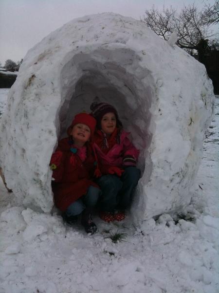 Katie and Libby Cox, aged  6 and 4, esacpe the chill in their igloo