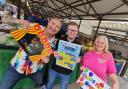 Scott Simpson, general manager of Tudor Markets, at Dudley Market with children's entertainers Will E Droppit and Tracy's Party Fun.