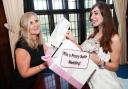 Superindendent Registrar Penny Fulford, and volunteer Hannah Detheridge, who is modelling one of the dresses at the Priory Hall open day, urge people to try to win a wedding at Priory Hall