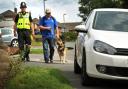Sgt Richard Cruickshank with Karl Denning and his dog Quasia approach a car parked on the pavement in Brownswall Road Sedgley.