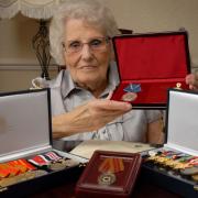 Phyllis Coyle - holding the Ushakov medal and, front, the commemorative 70th anniversary medal issued by the Russian Embassy.