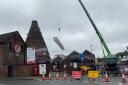 A crane lifts scaffolding onto the site of the Red House Glass Cone at Wordsley